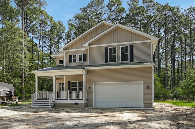 view of front of property with an attached garage, dirt driveway, a porch, a standing seam roof, and metal roof