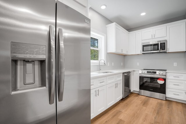 kitchen featuring light countertops, a sink, white cabinets, and stainless steel appliances