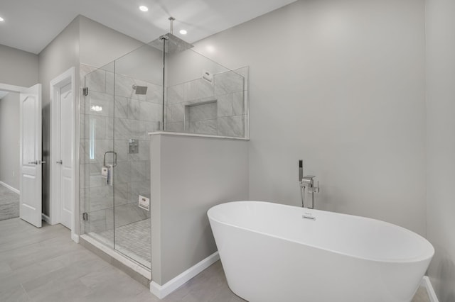 full bathroom featuring baseboards, recessed lighting, a soaking tub, and a shower stall