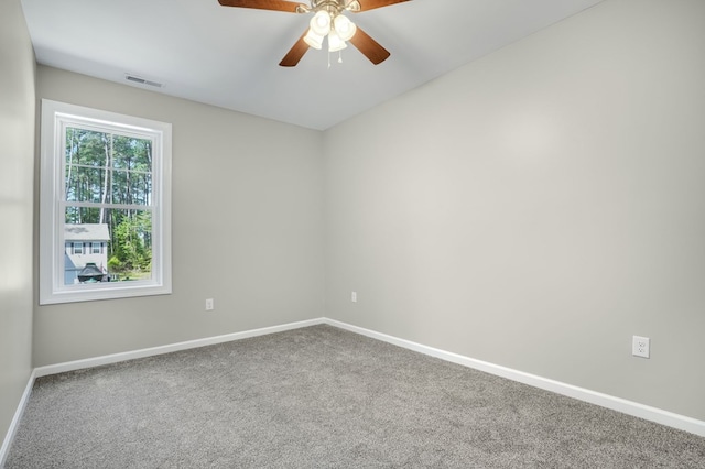 carpeted empty room with visible vents, a ceiling fan, and baseboards