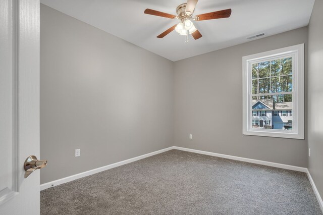 carpeted empty room with visible vents, a ceiling fan, and baseboards