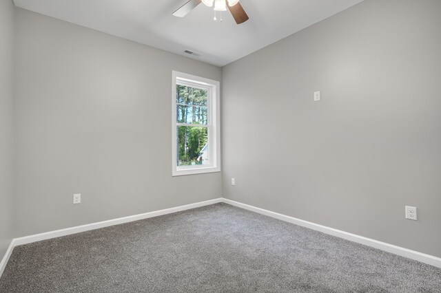 empty room with ceiling fan, visible vents, baseboards, and carpet