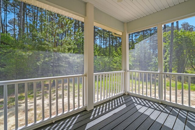 unfurnished sunroom with ceiling fan