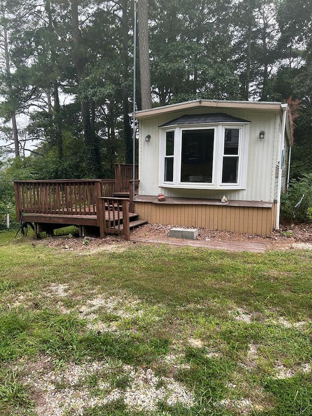 back of house with a lawn and a wooden deck