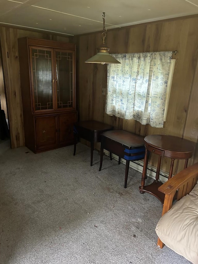 dining space featuring carpet flooring and wood walls