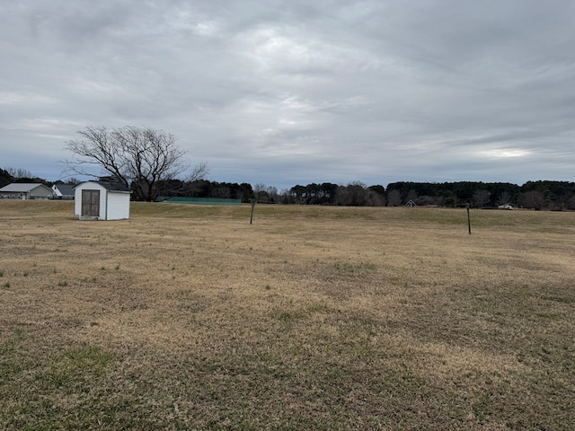 view of yard featuring a storage shed and a rural view