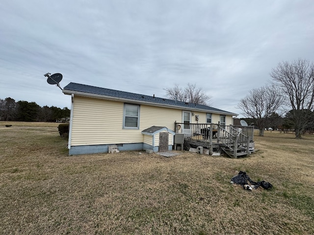 back of property with a wooden deck and a lawn