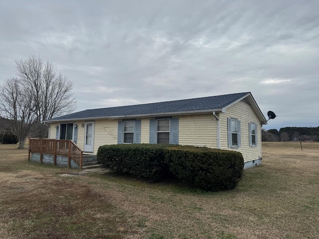 view of side of property featuring a yard and a deck