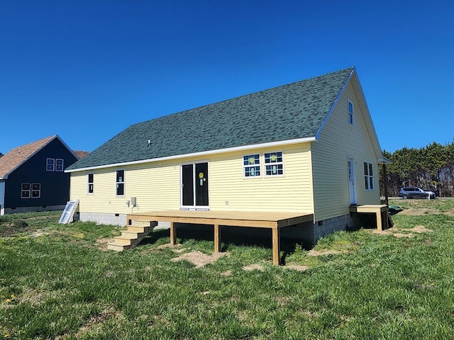 back of property with a shingled roof, a yard, and a wooden deck