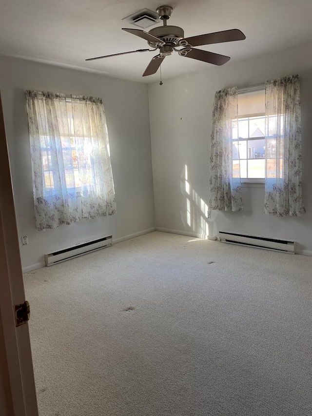 empty room with carpet flooring, ceiling fan, and a baseboard radiator