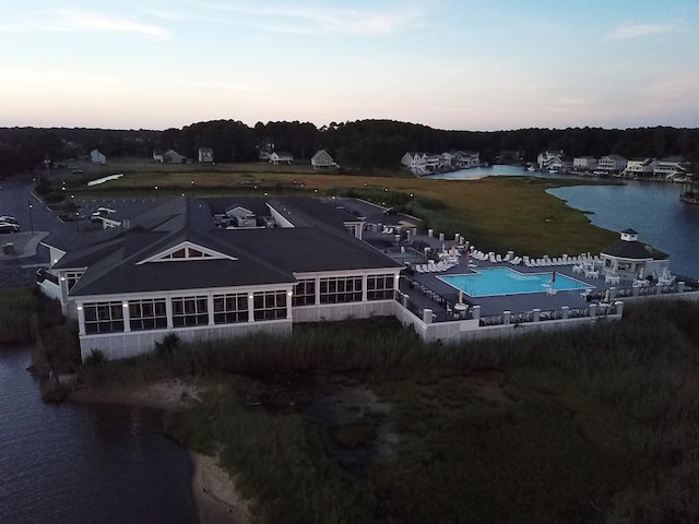 aerial view at dusk featuring a water view