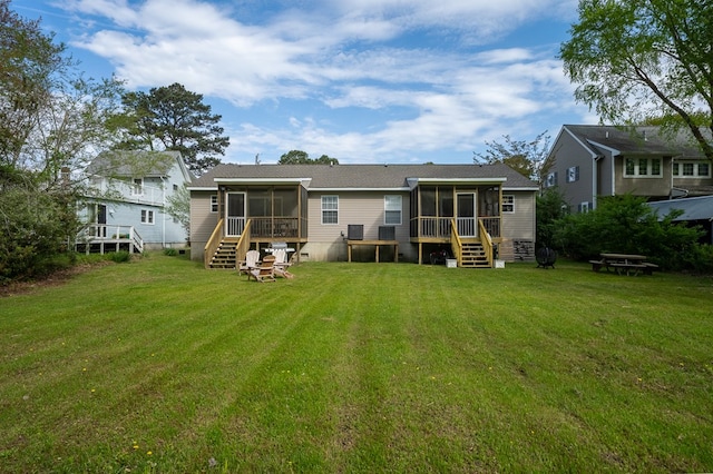rear view of property with a yard, a sunroom, and stairway