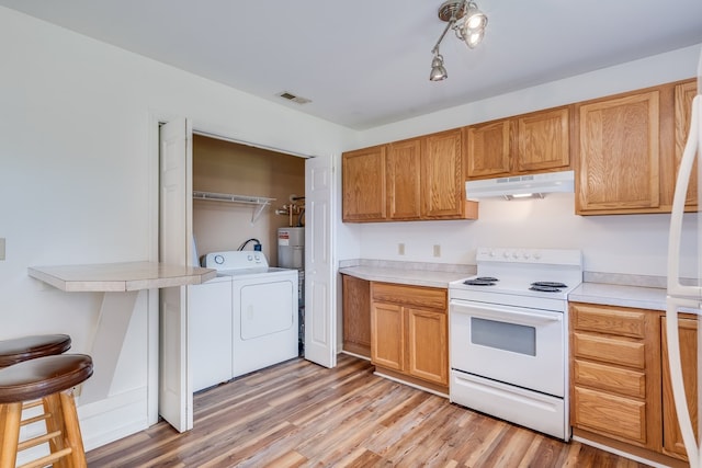 kitchen featuring washing machine and dryer, white appliances, light wood-type flooring, light countertops, and under cabinet range hood