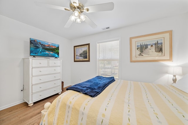 bedroom with ceiling fan, baseboards, visible vents, and wood finished floors