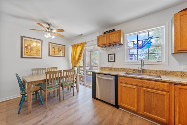 kitchen with a wealth of natural light, a sink, light wood finished floors, and dishwasher