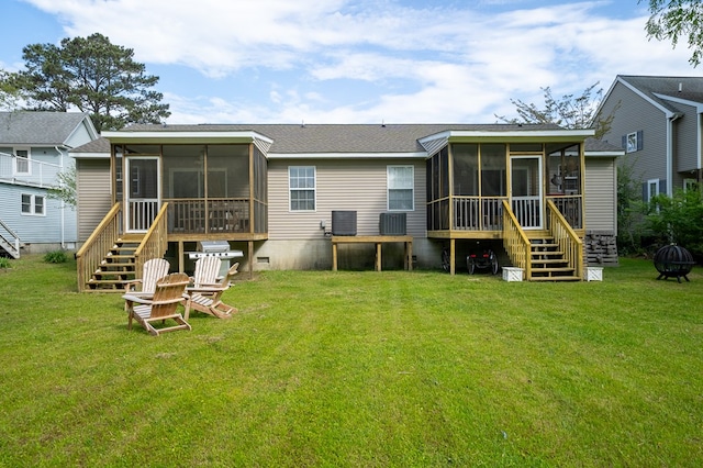 back of property with a yard, stairs, and a sunroom