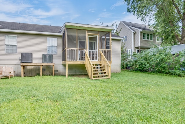 back of house with a yard, a sunroom, and central AC