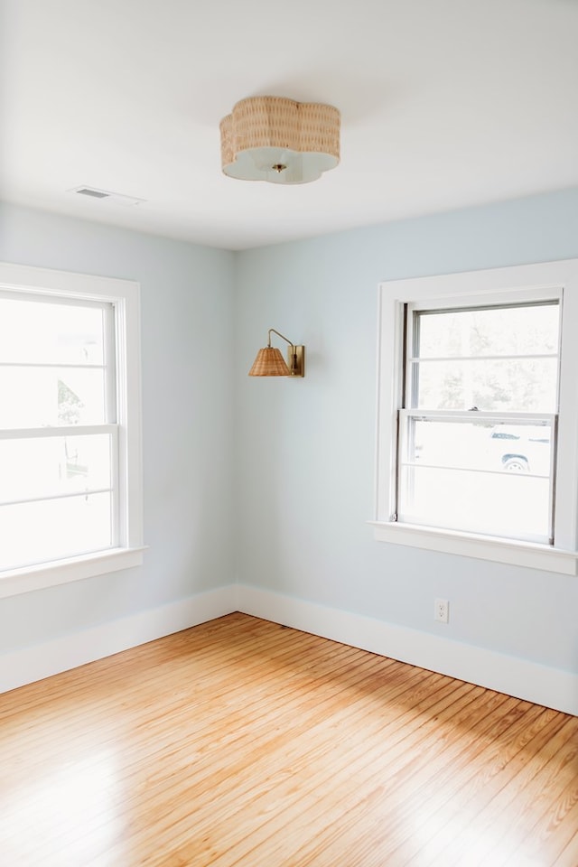 spare room featuring baseboards and wood finished floors