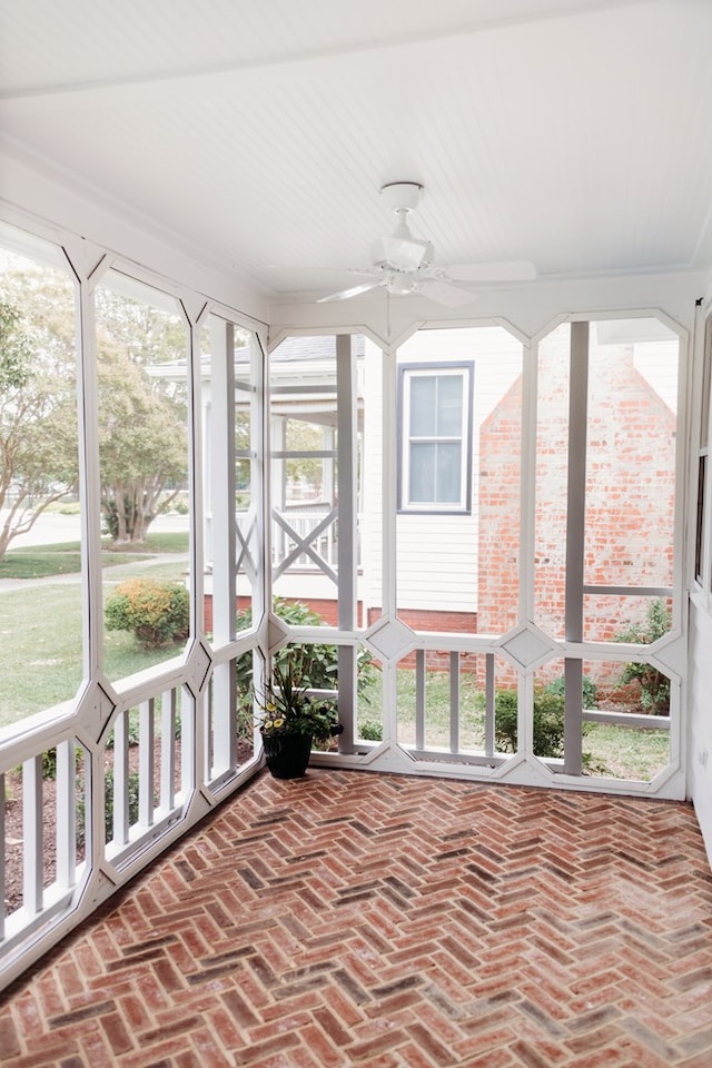 unfurnished sunroom with a ceiling fan