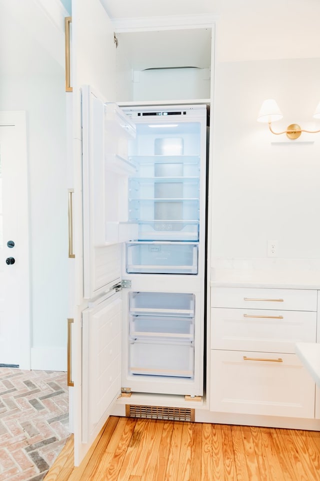 interior space featuring light countertops, white cabinets, and fridge