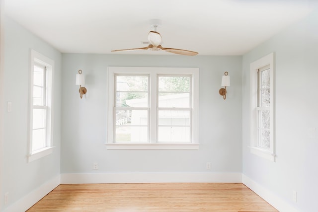 spare room with a ceiling fan, baseboards, and light wood-type flooring