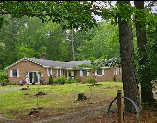21020 Adams Rd, Greenbush, VA 23357 - view of front of house with a front lawn, a chimney, and brick siding