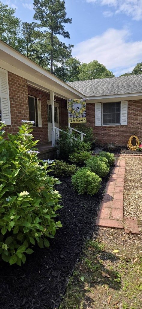 21020 Adams Rd, Greenbush, VA 23357 - doorway to property with brick siding and a shingled roof