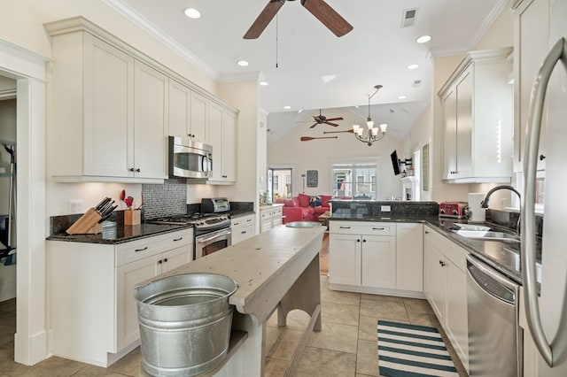 kitchen with visible vents, ornamental molding, a sink, appliances with stainless steel finishes, and ceiling fan with notable chandelier