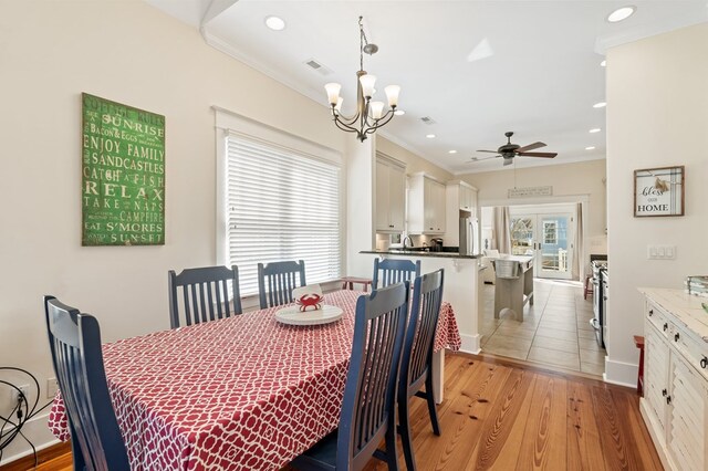 dining space with visible vents, ornamental molding, recessed lighting, ceiling fan with notable chandelier, and light wood-style floors