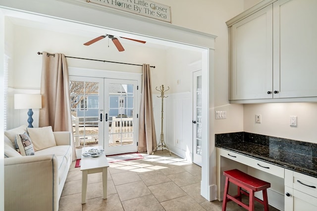 interior space with light tile patterned floors, french doors, and ceiling fan