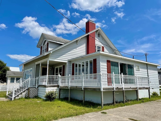 view of side of property with a lawn and a porch