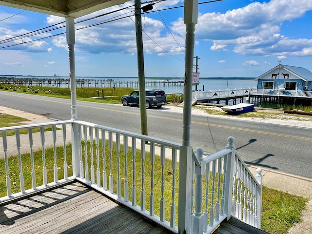 wooden terrace featuring covered porch and a water view