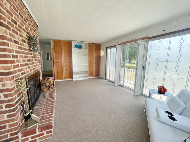 unfurnished living room featuring carpet flooring and a brick fireplace