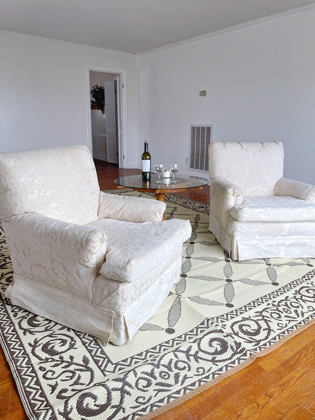 living room with wood-type flooring and ornamental molding