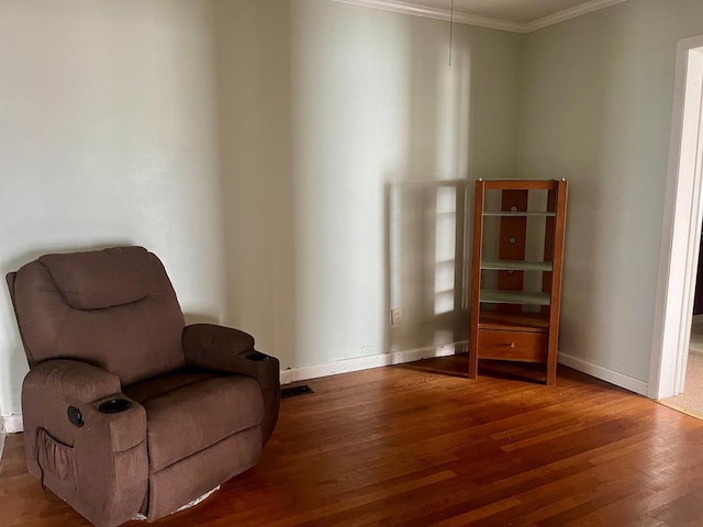 sitting room featuring wood-type flooring and crown molding