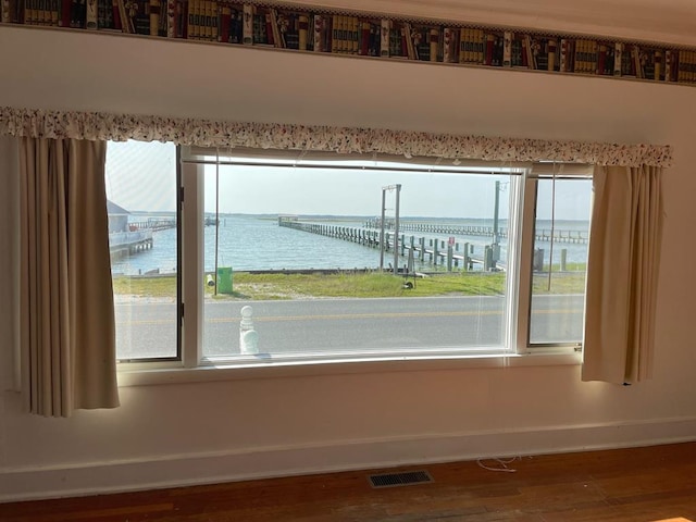 unfurnished room featuring a water view and hardwood / wood-style flooring