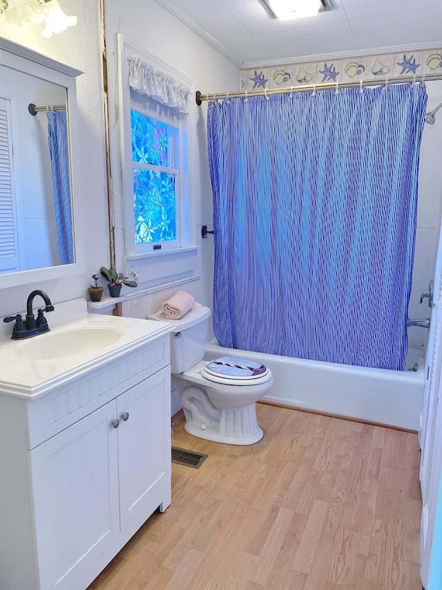 full bathroom with vanity, hardwood / wood-style flooring, toilet, ornamental molding, and shower / tub combo