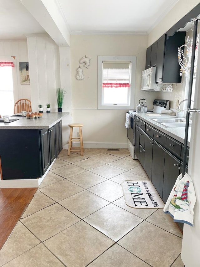 kitchen with stainless steel electric range, crown molding, light tile patterned floors, and sink