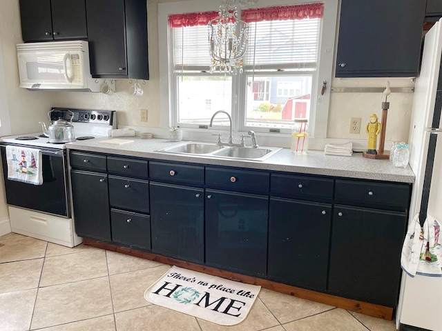 kitchen with light tile patterned floors, white appliances, an inviting chandelier, and sink