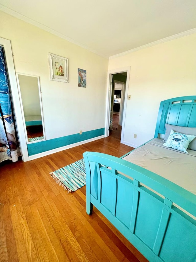 unfurnished bedroom with wood-type flooring and ornamental molding