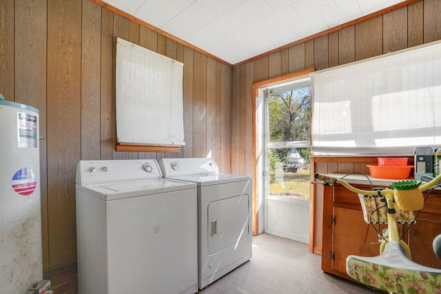 laundry room featuring ornamental molding, washing machine and dryer, wooden walls, and water heater