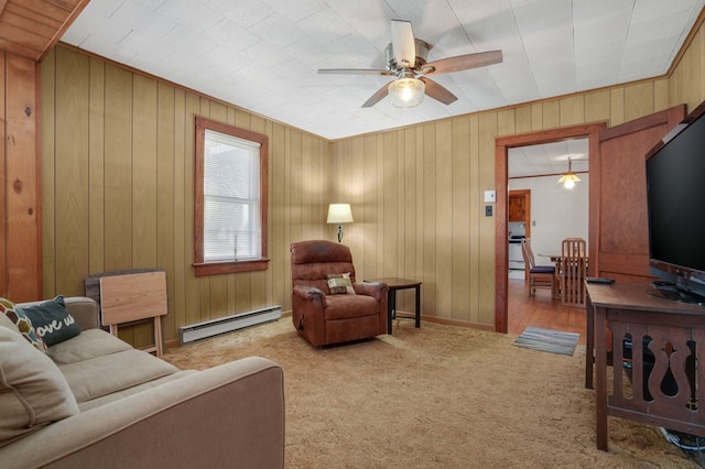 carpeted living room with baseboard heating, ceiling fan, and wooden walls