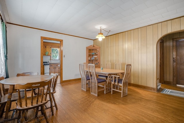 dining room with ornamental molding and light wood-type flooring
