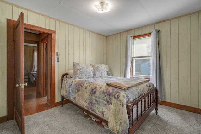 bedroom featuring wooden walls and carpet floors