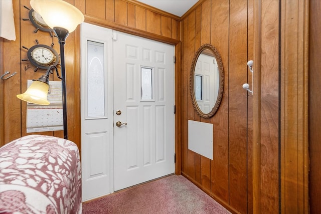 carpeted entrance foyer with wooden walls