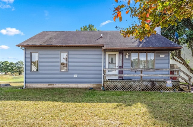 rear view of house with a wooden deck and a lawn