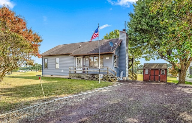 view of front of house featuring a front lawn and a storage unit