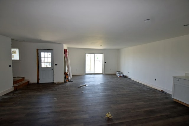 3365 Peaceful Ln, Chincoteague, VA 23336 - unfurnished living room with healthy amount of natural light, dark wood-type flooring, and baseboards