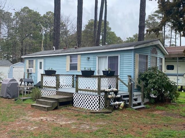 back of property featuring a sunroom and a wooden deck