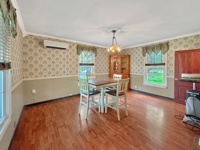 25539 Shoremain Dr, Bloxom, VA 23308 - dining area featuring a wall mounted AC, wallpapered walls, wainscoting, wood finished floors, and healthy amount of natural light